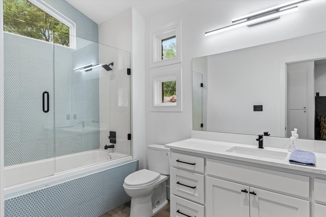 full bathroom with plenty of natural light, enclosed tub / shower combo, toilet, and oversized vanity