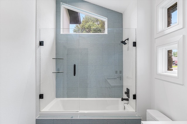 bathroom featuring enclosed tub / shower combo and toilet