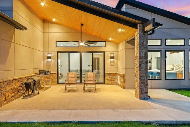 patio terrace at dusk featuring ceiling fan