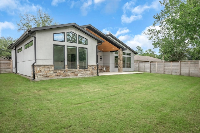 back of house with a patio and a lawn