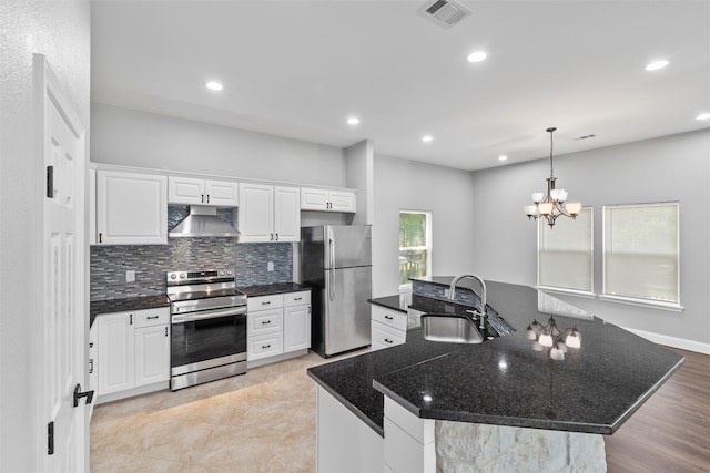 kitchen featuring tasteful backsplash, stainless steel appliances, decorative light fixtures, sink, and white cabinets