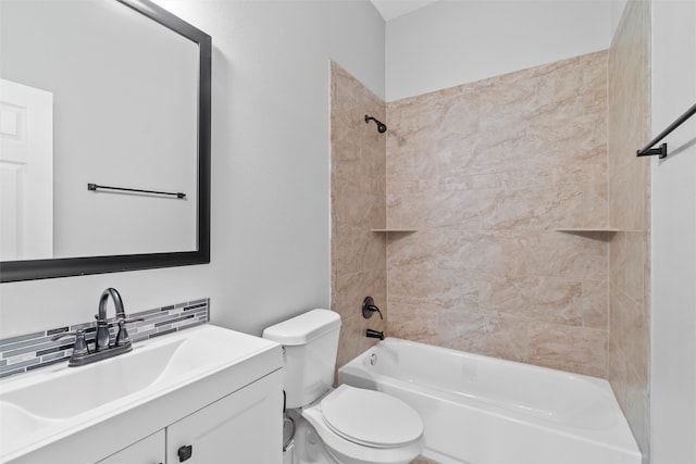 full bathroom featuring tiled shower / bath, vanity with extensive cabinet space, and toilet