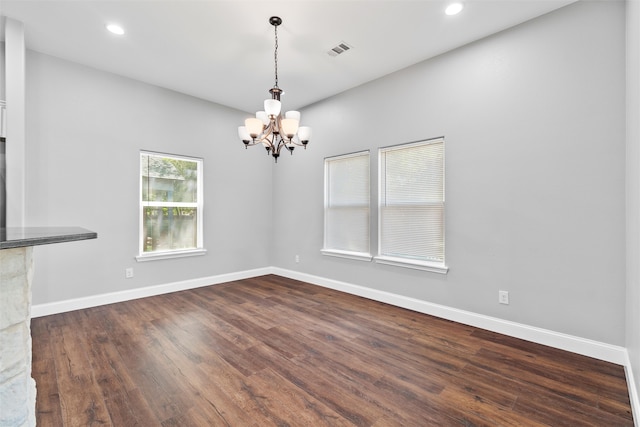 unfurnished living room with dark hardwood / wood-style flooring and a chandelier