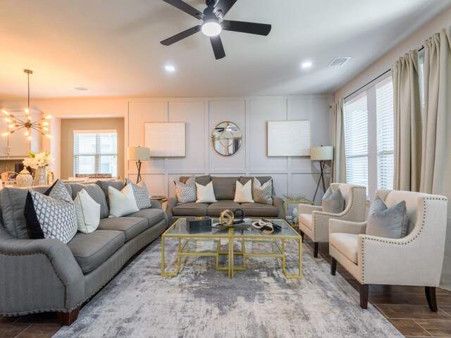 living room featuring ceiling fan with notable chandelier