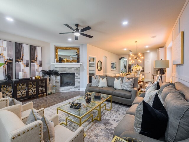 living room featuring ceiling fan with notable chandelier and hardwood / wood-style flooring