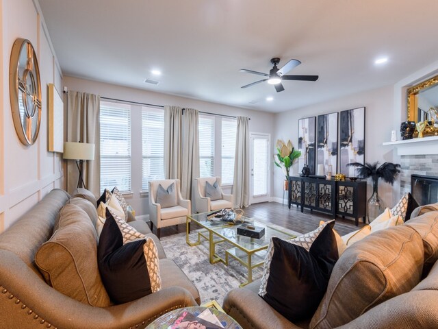 living room featuring light hardwood / wood-style floors, ceiling fan, and a fireplace