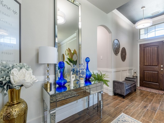 entrance foyer with dark wood-type flooring and ornamental molding