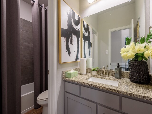 full bathroom featuring vanity, shower / bathtub combination with curtain, and toilet