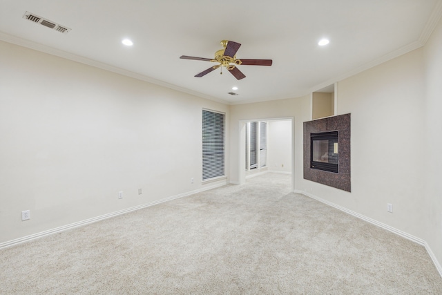 unfurnished living room with ceiling fan, crown molding, and light colored carpet