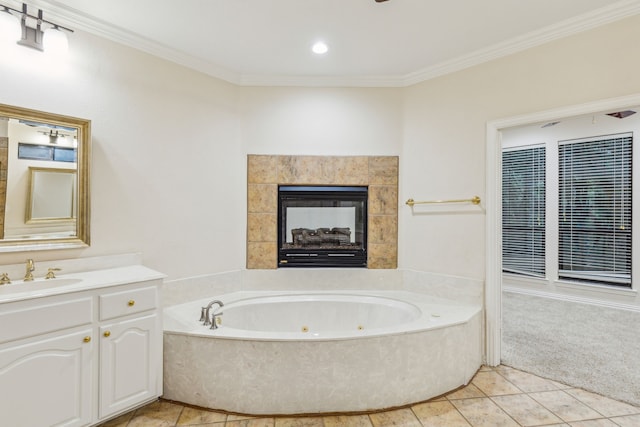 bathroom featuring tile floors, a tiled fireplace, vanity, and a washtub