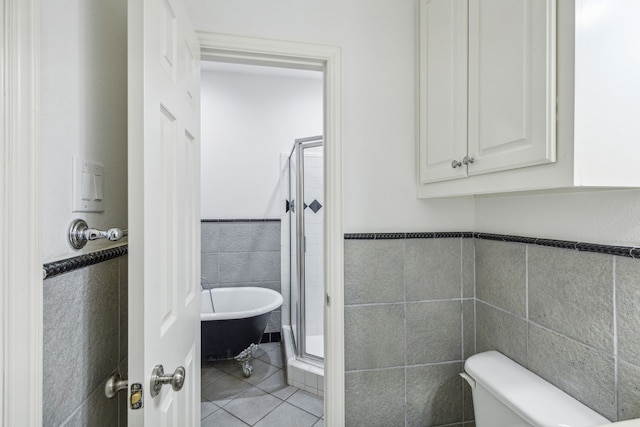 bathroom with tile floors, plus walk in shower, toilet, and tile walls