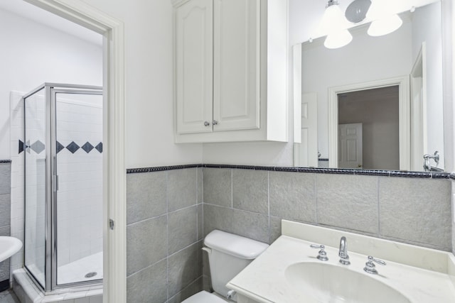 bathroom featuring sink, tile walls, toilet, and a shower with door