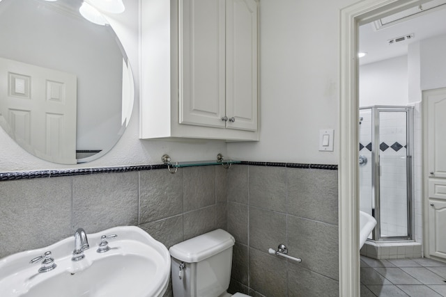 bathroom featuring tile flooring, an enclosed shower, tile walls, sink, and toilet