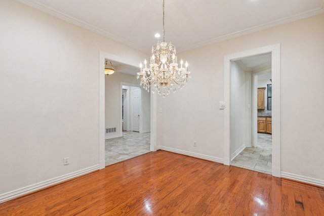 spare room featuring a chandelier, ornamental molding, and light tile flooring