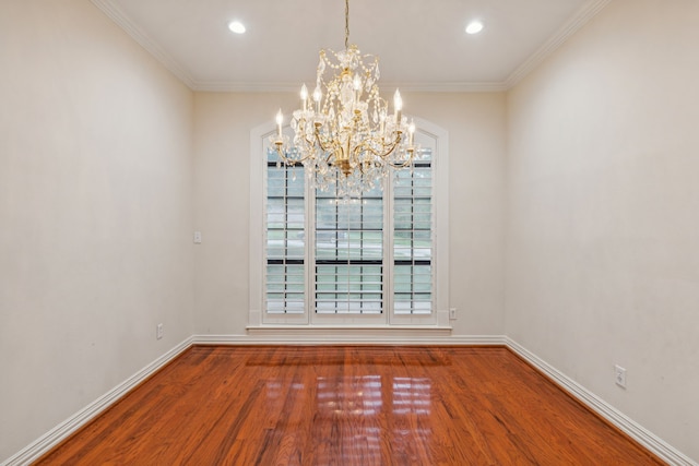 spare room featuring a chandelier, hardwood / wood-style flooring, and crown molding