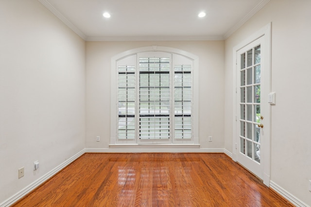 empty room featuring crown molding and wood-type flooring