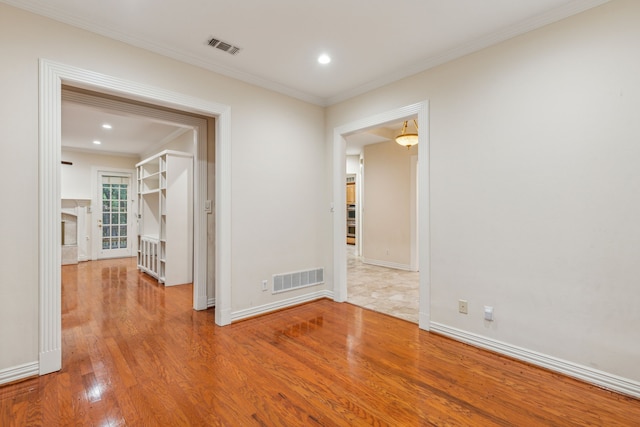 empty room featuring tile floors and crown molding