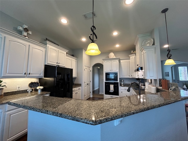 kitchen featuring pendant lighting, dark stone countertops, white cabinets, and black appliances