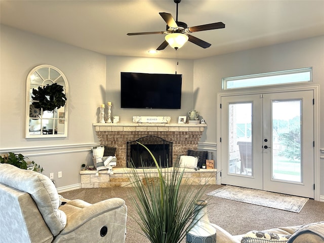 carpeted living room featuring a fireplace, french doors, and ceiling fan