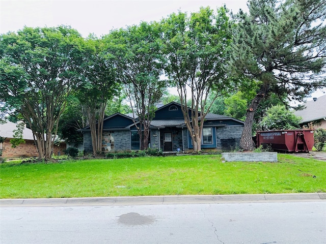 single story home featuring a front lawn and a wooden deck