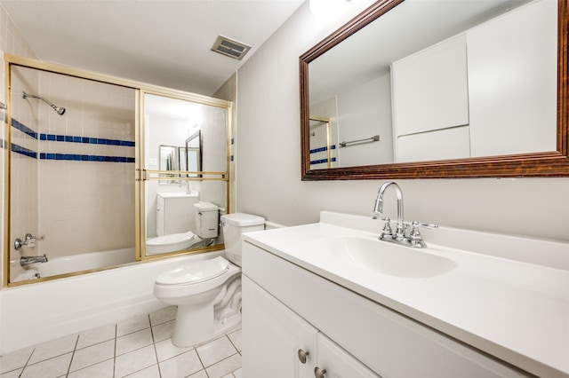 full bathroom featuring vanity with extensive cabinet space, toilet, combined bath / shower with glass door, and tile flooring