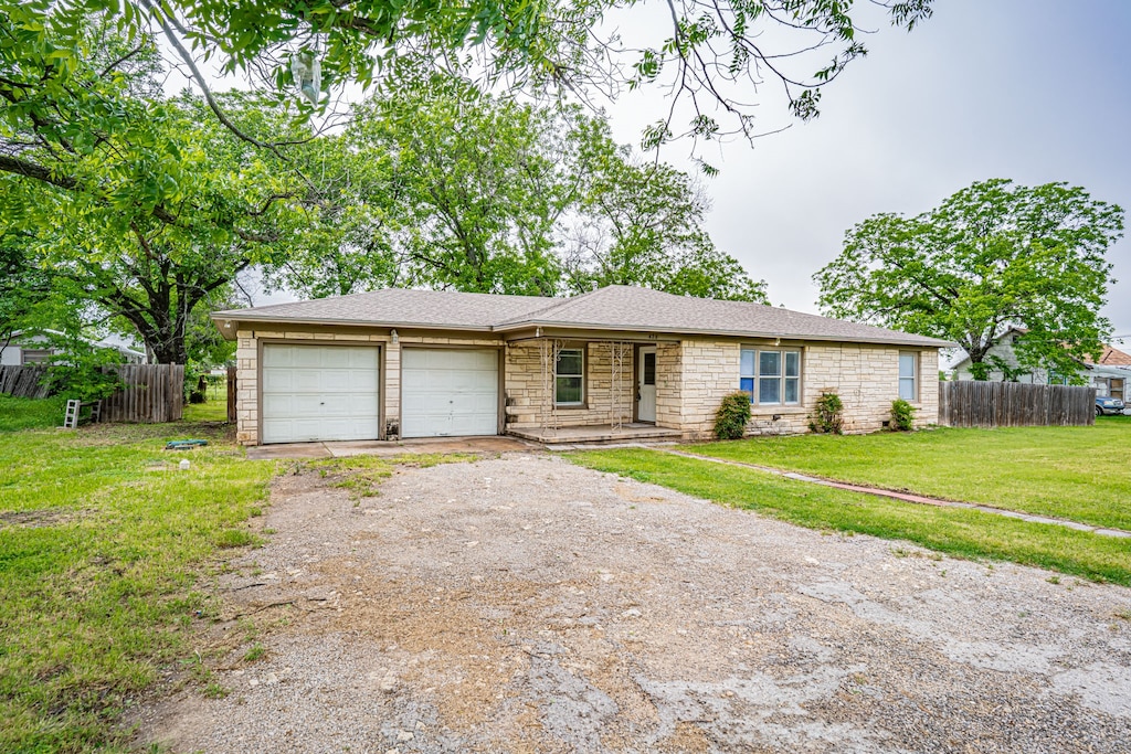 ranch-style home with a front yard and a garage