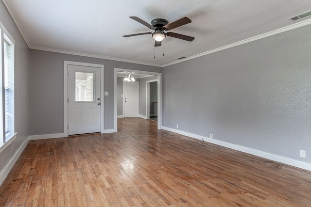 entryway with a wealth of natural light, ornamental molding, wood-type flooring, and ceiling fan