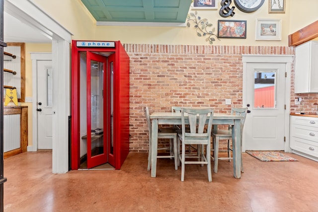 dining area featuring brick wall