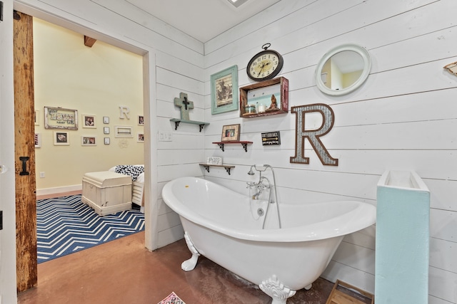 bathroom with a bathing tub and wood walls