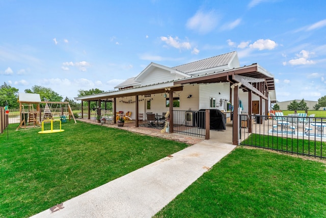 back of house with a playground, a patio area, a fenced in pool, a lawn, and ceiling fan