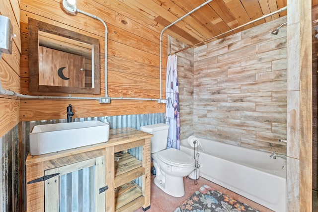 full bathroom with vanity, toilet, wooden walls, and shower / bathtub combination with curtain