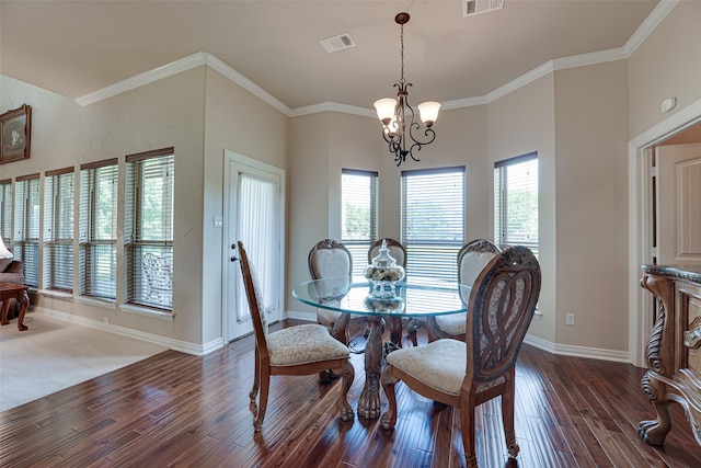 dining room with ornamental molding, dark carpet, and an inviting chandelier