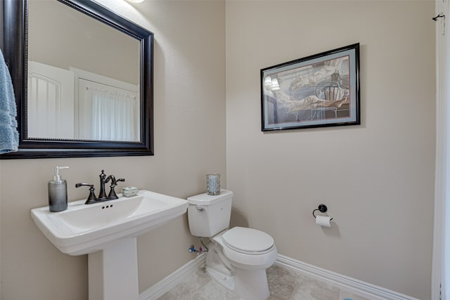 bathroom with toilet and tile floors