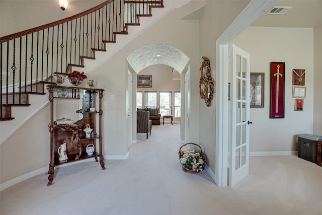 interior space featuring a towering ceiling and carpet