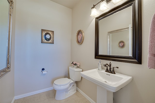 bathroom featuring sink, toilet, and tile flooring