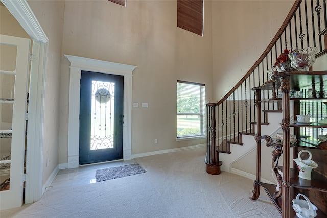 entryway featuring a towering ceiling and carpet floors