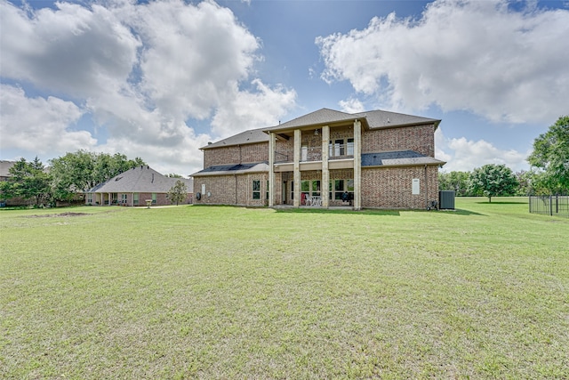 rear view of property featuring a yard and a balcony