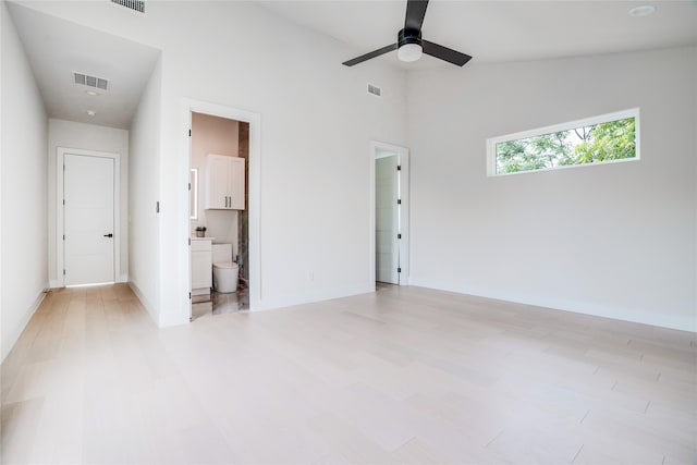 unfurnished bedroom with high vaulted ceiling, ceiling fan, ensuite bath, and light tile floors