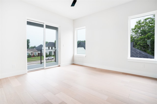 empty room with a healthy amount of sunlight and light hardwood / wood-style flooring