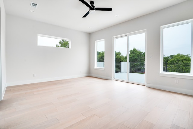 spare room with ceiling fan, a healthy amount of sunlight, and light hardwood / wood-style floors