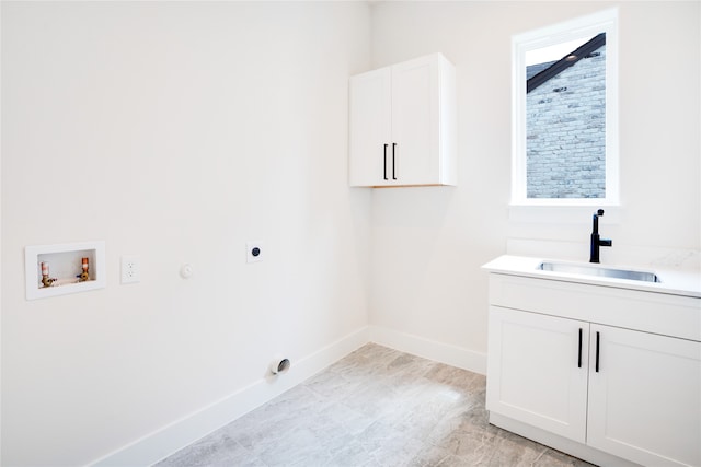 clothes washing area featuring cabinets, electric dryer hookup, hookup for a washing machine, sink, and light tile floors