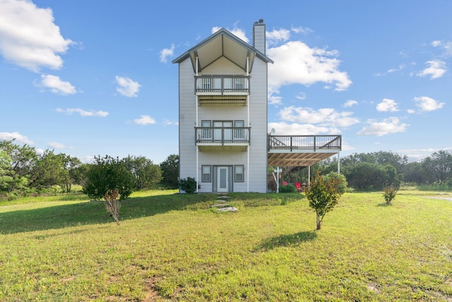 back of house featuring a balcony and a lawn