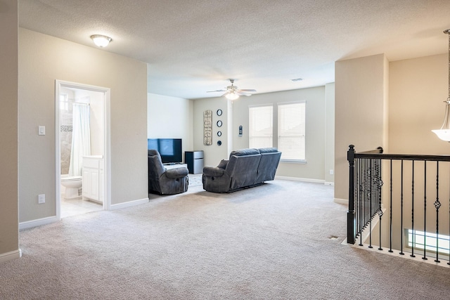 living room with baseboards, a ceiling fan, carpet, and a textured ceiling