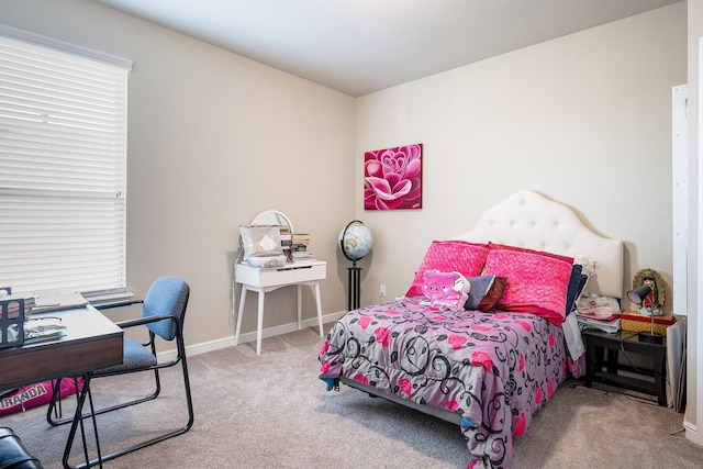 carpeted bedroom featuring baseboards and multiple windows