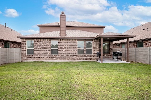 rear view of house featuring a patio area and a lawn