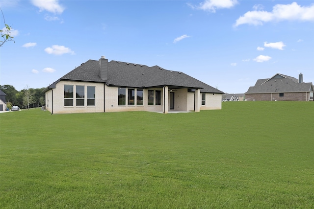 rear view of house featuring a lawn and a patio area