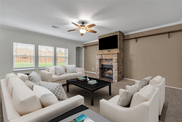 living room featuring carpet, ceiling fan, crown molding, and a fireplace