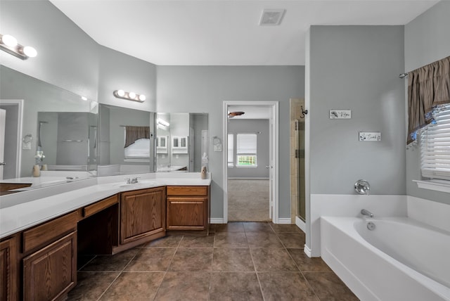 bathroom featuring tile patterned flooring, shower with separate bathtub, and vanity