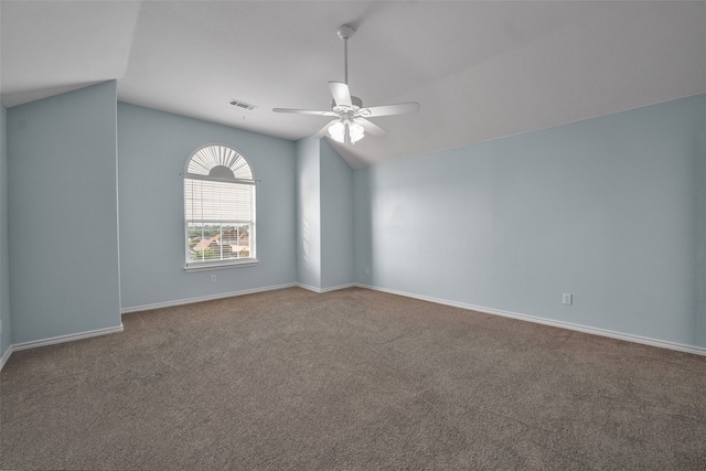 carpeted spare room featuring ceiling fan and vaulted ceiling