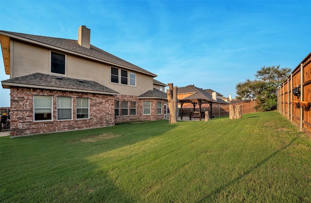 back of house featuring a gazebo and a yard